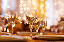 Auf einem festlichen geschmückten Tisch stehen mehrere Gläser.