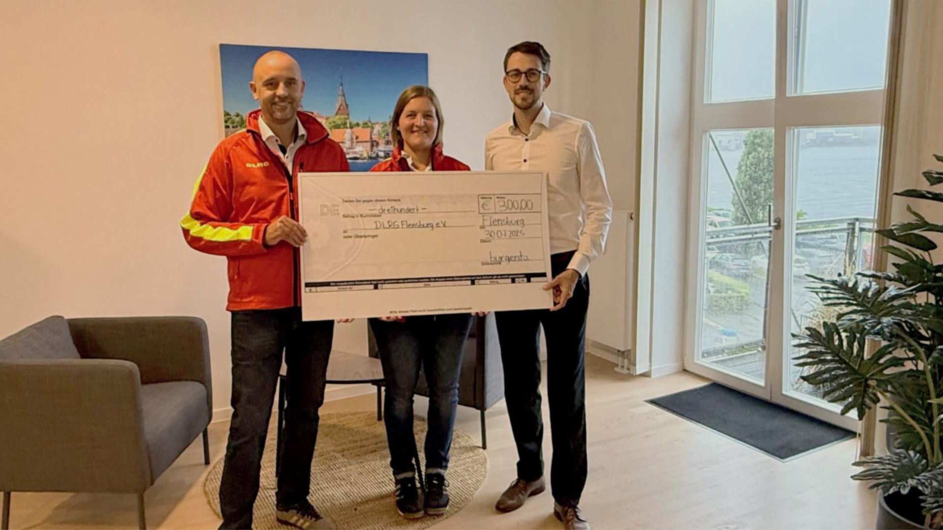 Übergabe eines Spendenschecks über 300 Euro von burgenta an die DLRG Flensburg e.V.