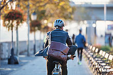 Ein Mann mit Aktentasche fährt auf einem Fahrrad. 