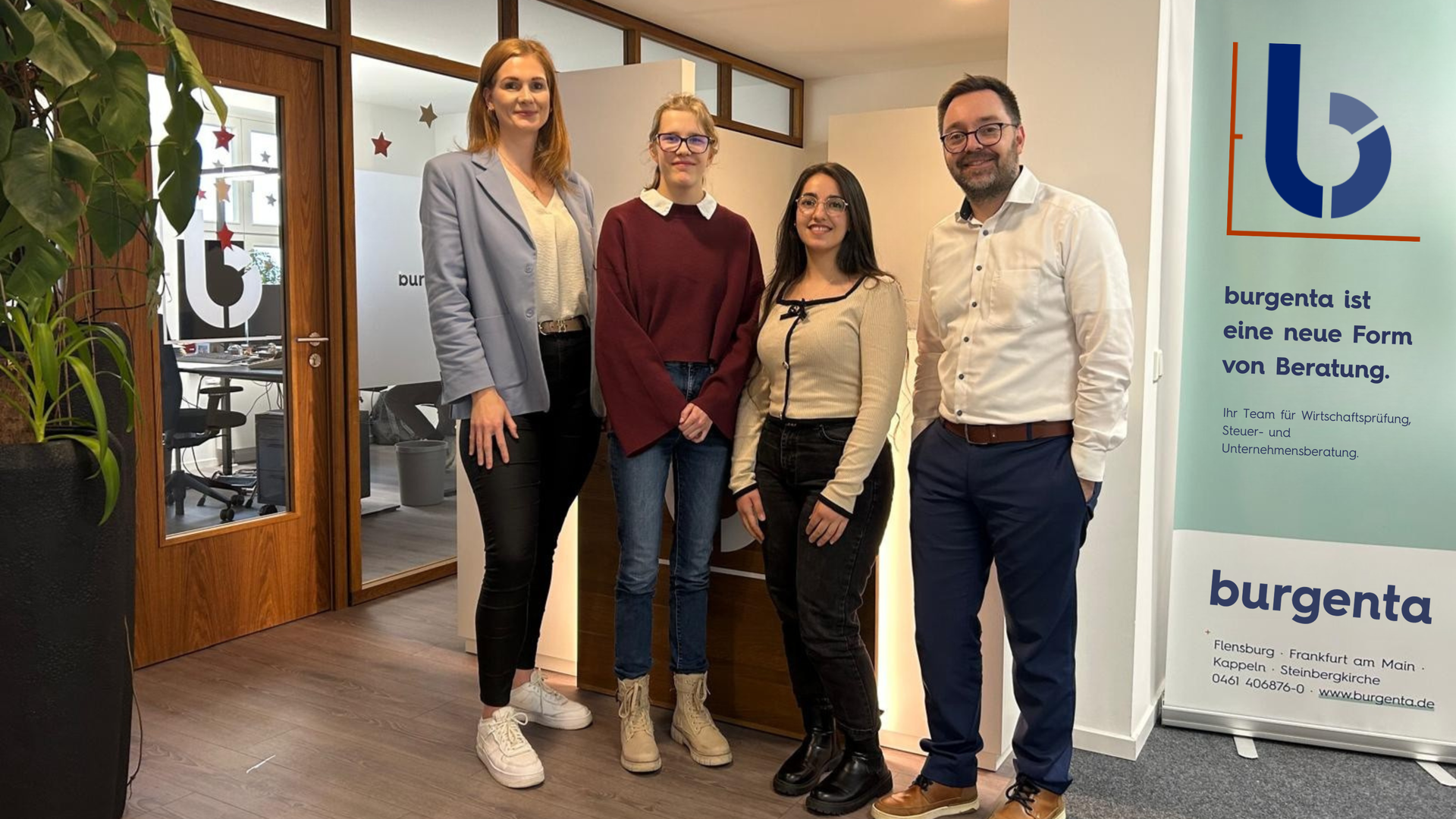 Zwei Steuerberater*innen von burgenta stehen mit zwei Teilnehmerinnen der Aktion "Dein Tag als Führungskraft" lächelnd im Büro bei burgenta.