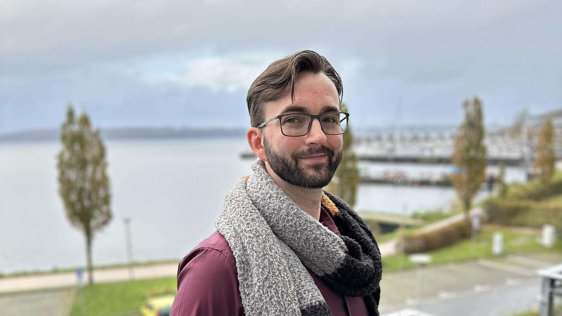 Portrait von burgenta-Mitarbeiter Frank vor der Marina Sonwik in Flensburg.